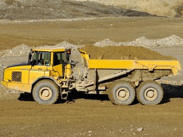 An articulated haul truck loaded with soil.