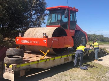 A roller on the back of a truck trailer being restrained.