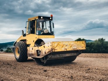 Roller compacting soil on a road.