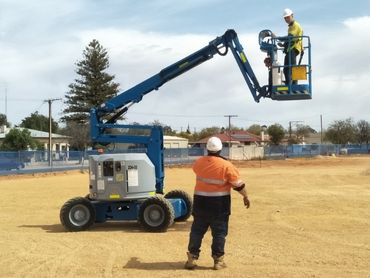 Man providing direction to a worker in an elevating work platform.