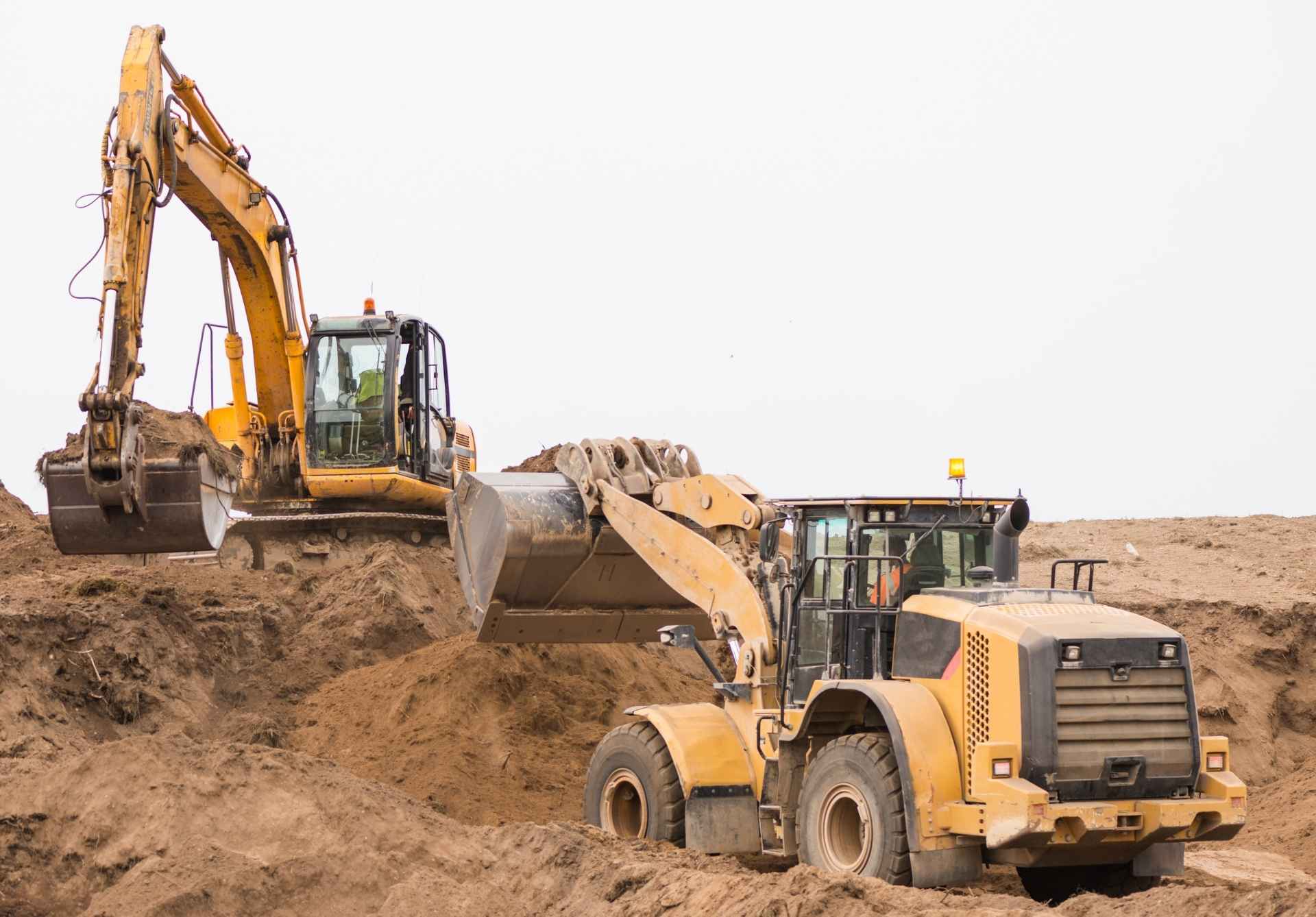 A loader and an excavator moving soil